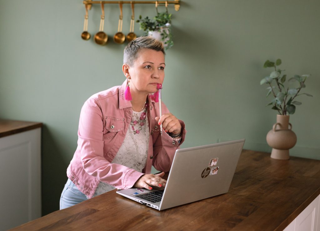 Jerabek-Karlovich Andi webdesigner és Kajabi szakértő laptopnál dolgozik